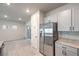 Modern kitchen with stainless appliances, granite countertops, and grey cabinets at 7477 Onyx Star St, North Las Vegas, NV 89084