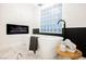 Modern bathroom features a standalone tub, electric fireplace, and a window block letting in plenty of natural light at 7695 Silver Wells Rd, Las Vegas, NV 89149