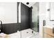 Modern bathroom features a glass enclosed shower with black accents and contrasting white and black tile at 7695 Silver Wells Rd, Las Vegas, NV 89149