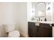 Modern powder room featuring dark cabinets, a white countertop, contemporary lighting, and neutral wall tiles at 7695 Silver Wells Rd, Las Vegas, NV 89149
