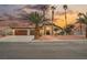 Charming home with a well-manicured lawn, mature palm trees, and a three-car garage at 7695 Silver Wells Rd, Las Vegas, NV 89149