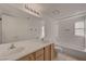Bright bathroom features a double sink vanity, tiled floor, tub with shower, and built-in storage niche at 8329 Telescope Peak Ct, Las Vegas, NV 89145