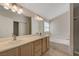 Well-lit bathroom with double sinks, a large mirror, and a separate bathtub and shower at 8329 Telescope Peak Ct, Las Vegas, NV 89145