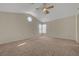 Spacious carpeted bedroom featuring a modern ceiling fan and ample natural light from a corner window at 8329 Telescope Peak Ct, Las Vegas, NV 89145