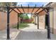 Charming pergola provides a shaded seating area overlooking the artificial turf and landscape at 8912 Galena Crossing St, Las Vegas, NV 89123