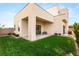 Backyard featuring a covered patio, lush green lawn, and contemporary home design with clean lines at 9780 Solar Ave, Las Vegas, NV 89149