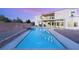 Spacious backyard featuring a large, modern pool and a sleek, contemporary home design, at dusk at 9780 Solar Ave, Las Vegas, NV 89149