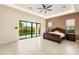 Large bedroom with a dark wood bed frame and sliding doors leading to the backyard at 9780 Solar Ave, Las Vegas, NV 89149