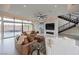 Bright living room boasts floor-to-ceiling windows, modern fireplace, and staircase to the upper level at 9780 Solar Ave, Las Vegas, NV 89149