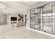 Open-concept living room featuring a fireplace, TV, staircase, and a glass enclosed wine room with unique design at 9780 Solar Ave, Las Vegas, NV 89149