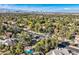 View of a neighborhood with lush landscaping and a few homes with private pools at 1 Quail Run Rd, Henderson, NV 89014