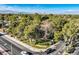 View of a neighborhood with lush landscaping and the Las Vegas skyline in the distance at 1 Quail Run Rd, Henderson, NV 89014