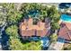 Stunning aerial view of a home with a terracotta roof, lush landscaping, and two sparkling pools at 1 Quail Run Rd, Henderson, NV 89014