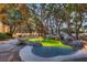 Lush backyard oasis boasting a custom pool, mature trees, and stylish lighting at 1 Quail Run Rd, Henderson, NV 89014