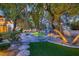 Serene backyard showcasing a custom pool, mature trees, and comfortable seating at 1 Quail Run Rd, Henderson, NV 89014
