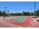 Community basketball court with red and green surfaces, surrounded by trees and benches at 1 Quail Run Rd, Henderson, NV 89014