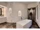 Bright bathroom boasts a modern tub, decorative chandelier and tiled walls at 1 Quail Run Rd, Henderson, NV 89014