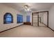 Bright bedroom with arched window, neutral carpeting, and mirrored closet at 1 Quail Run Rd, Henderson, NV 89014