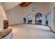 Spacious living room with a vaulted ceiling, large windows, and a charming brick fireplace at 1 Quail Run Rd, Henderson, NV 89014