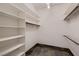Walk-in closet with built-in shelving and stone floors at 1 Quail Run Rd, Henderson, NV 89014