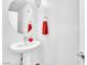 Clean powder room featuring a pedestal sink, modern fixtures, and a stylish round mirror at 12126 Azure Gate Rd # 1, Las Vegas, NV 89183