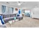 Comfortable living area with sectional sofa, glass coffee table, dining area and large windows at 12126 Azure Gate Rd # 1, Las Vegas, NV 89183