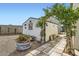 View of backyard with outbuilding with arbor, mature trees, flower pots and gravel at 1252 N Sloan Ln, Las Vegas, NV 89110