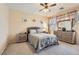 Carpeted bedroom featuring a queen bed, bedside tables, and dresser with a decorative mirror at 1252 N Sloan Ln, Las Vegas, NV 89110