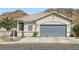 Inviting single-story home with a two-car garage and desert landscaping at 1252 N Sloan Ln, Las Vegas, NV 89110