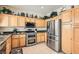 Well-lit kitchen featuring stainless steel appliances, light wood cabinets, and dark granite countertops at 1252 N Sloan Ln, Las Vegas, NV 89110