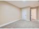 Neutral bedroom with a window providing natural light, plush carpet flooring, and a white door leading to another room at 143 Constitution Ave, Henderson, NV 89015