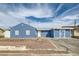 Charming single-story home with blue exterior, desert landscaping, and a driveway leading to an attached garage at 143 Constitution Ave, Henderson, NV 89015