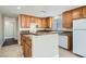 Well-lit kitchen with wood cabinets, tile floor, stone countertops, and white appliances at 143 Constitution Ave, Henderson, NV 89015