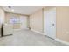 Bright laundry room featuring washer/dryer hookups, two white doors, light gray tile flooring, and a window at 143 Constitution Ave, Henderson, NV 89015