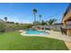 Well-manicured backyard showcasing a sparkling pool with spa, lush green grass, and a cozy outdoor seating area at 1547 Harwood Ave, Henderson, NV 89012