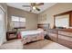 Comfortable bedroom featuring a ceiling fan, dresser, and a large window at 1547 Harwood Ave, Henderson, NV 89012