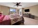 Primary bedroom with ceiling fan, balcony access, and flat screen tv at 1547 Harwood Ave, Henderson, NV 89012