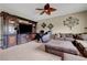 Cozy living room featuring a large entertainment center, comfortable seating, and a leaf-shaped ceiling fan at 1547 Harwood Ave, Henderson, NV 89012
