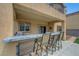 Covered outdoor kitchen bar area with seating offering a view of the backyard and pool at 1547 Harwood Ave, Henderson, NV 89012