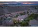 Expansive aerial view capturing the neighborhood, desert landscape, and distant mountains at sunset at 1624 Preston Park Dr, Henderson, NV 89052