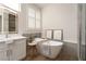 Bathroom featuring modern tub, shaker cabinets, and tiled glass-enclosed shower at 1624 Preston Park Dr, Henderson, NV 89052
