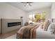 Bright bedroom with large window, modern fireplace, wood floors, and neutral furnishings at 1624 Preston Park Dr, Henderson, NV 89052