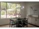 Charming dining area features a modern chandelier, sleek black furniture, and a beautiful view of the landscaped yard at 1624 Preston Park Dr, Henderson, NV 89052