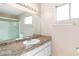 A full bathroom with granite countertops, mirror, shower, and window at 1775 Esteban Ave, Laughlin, NV 89029