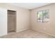 Bedroom with neutral carpeting, a window overlooking the yard, and a closet with sliding doors at 1775 Esteban Ave, Laughlin, NV 89029