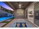 Covered patio with designer table overlooks a modern pool and spa against a hillside at 18 Via Tiberina, Henderson, NV 89011