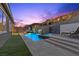 Lush backyard featuring a modern pool, spa, and waterfall, perfect for relaxation at 18 Via Tiberina, Henderson, NV 89011
