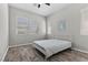 Serene bedroom features a bed, wood floors, three windows, and an abstract artwork for a relaxing retreat at 18 Via Tiberina, Henderson, NV 89011