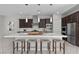 Beautiful kitchen with stainless steel appliances, dark cabinetry, and a large white quartz island with seating at 18 Via Tiberina, Henderson, NV 89011