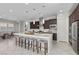 Bright and airy kitchen showcasing a center island, modern lighting, and stainless steel appliances at 18 Via Tiberina, Henderson, NV 89011